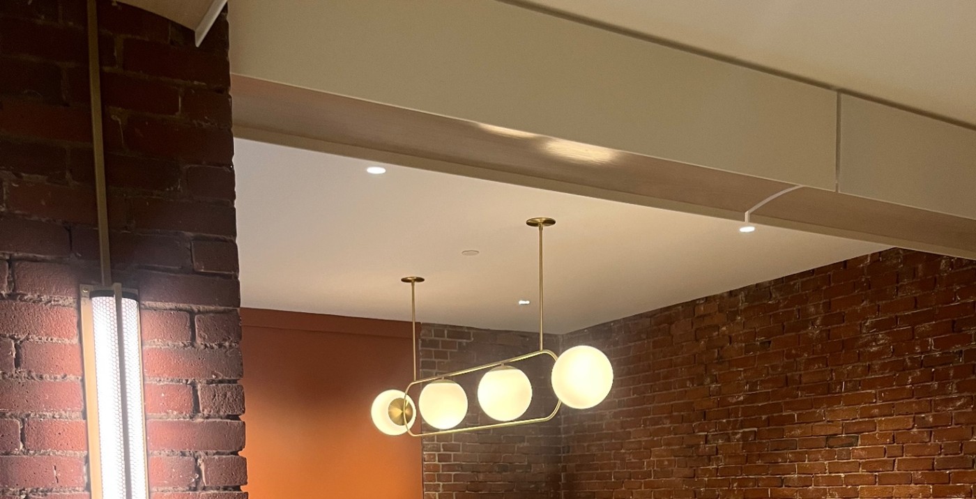 Brass globe pendant, recessed ceiling downlights and a brick column wall sconce installed in a South Shore lounge