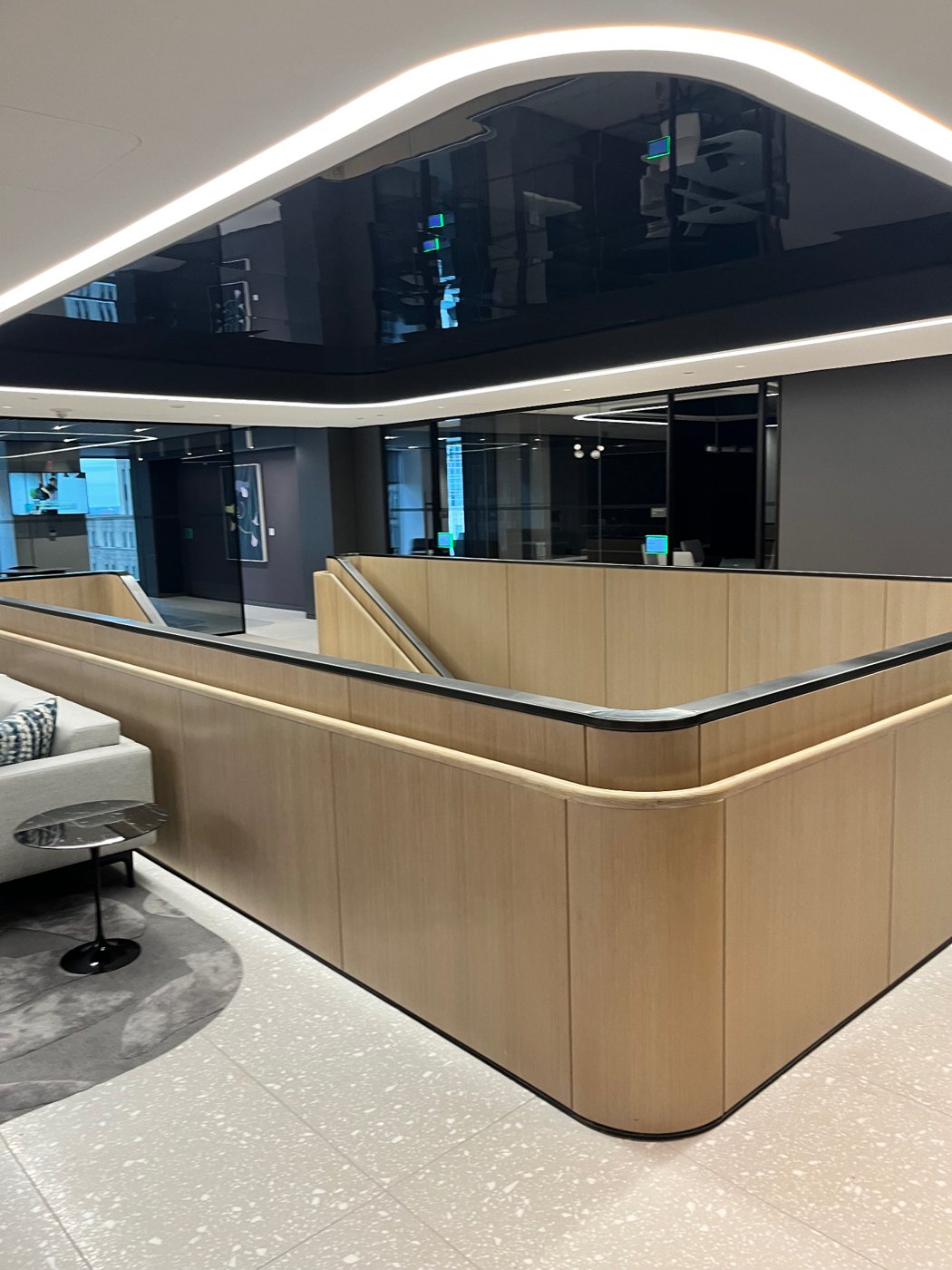 Curved LED cove lighting around a glossy recessed ceiling above an office stairwell